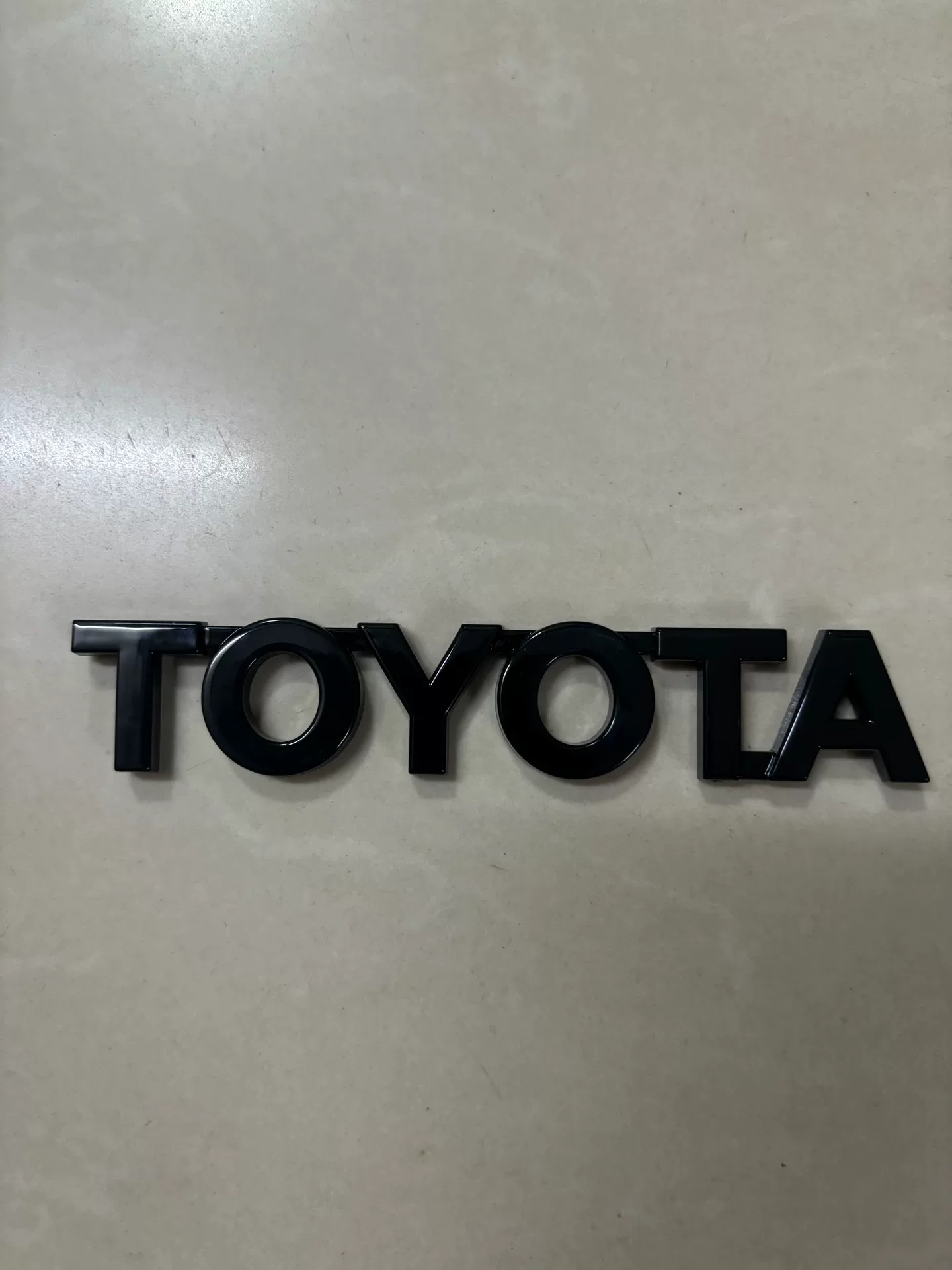 Toyota A90, A91 Used OEM Emblem Badge matte black, red accent A90 Toyota A90, A91 Used OEM Emblem Badge matte black, red accent A90 - detail image 5