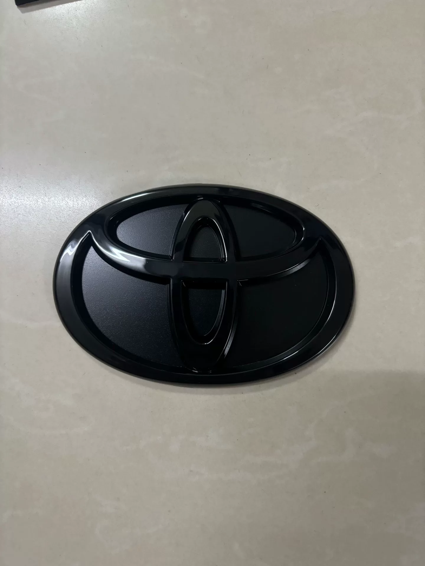 Toyota A90, A91 Used OEM Emblem Badge matte black, red accent A90 Toyota A90, A91 Used OEM Emblem Badge matte black, red accent A90 - detail image 2