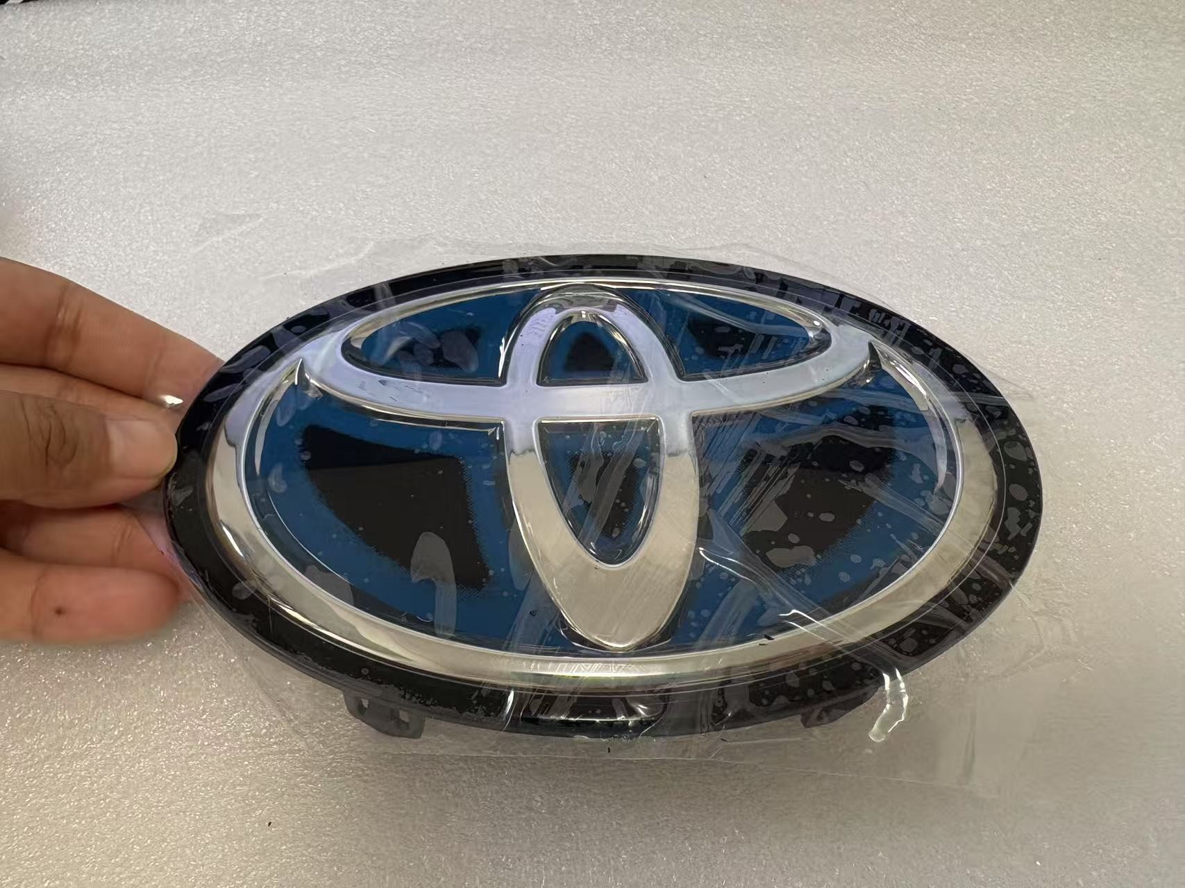 Toyota grille emblem with blue accent front view
