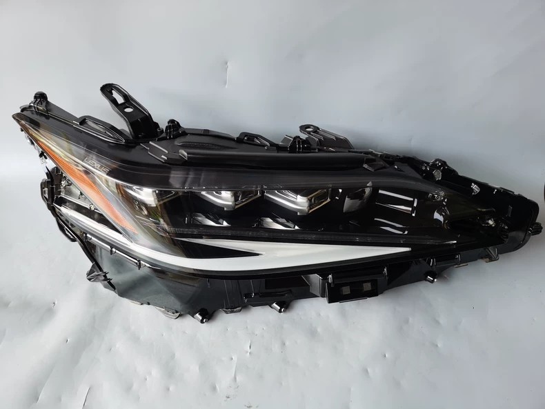 Genuine Lexus ES OEM LED headlight assembly front view - three LED projectors, LEXUS embossed lens and amber side reflector