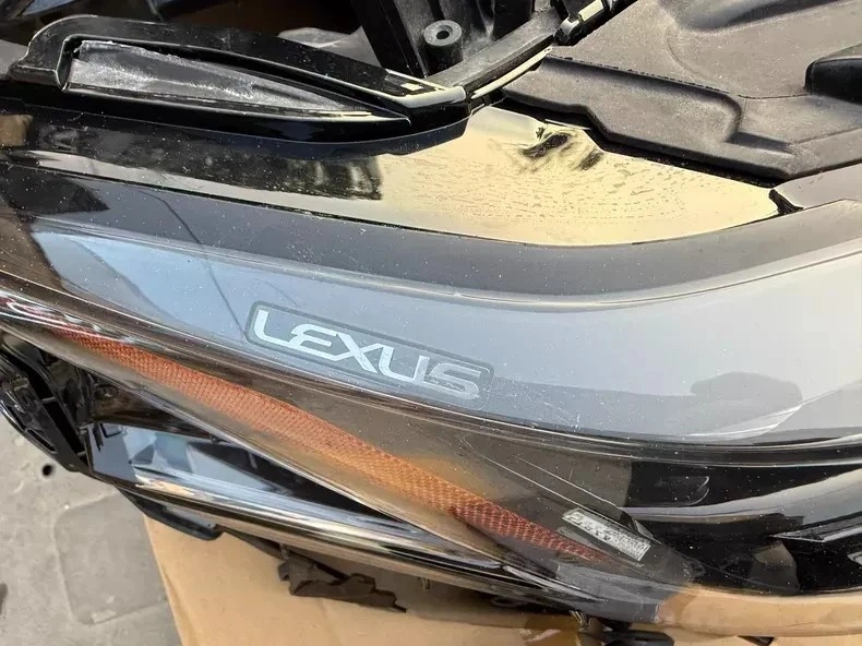 Lexus branding on the ES triple-beam LED headlight lens