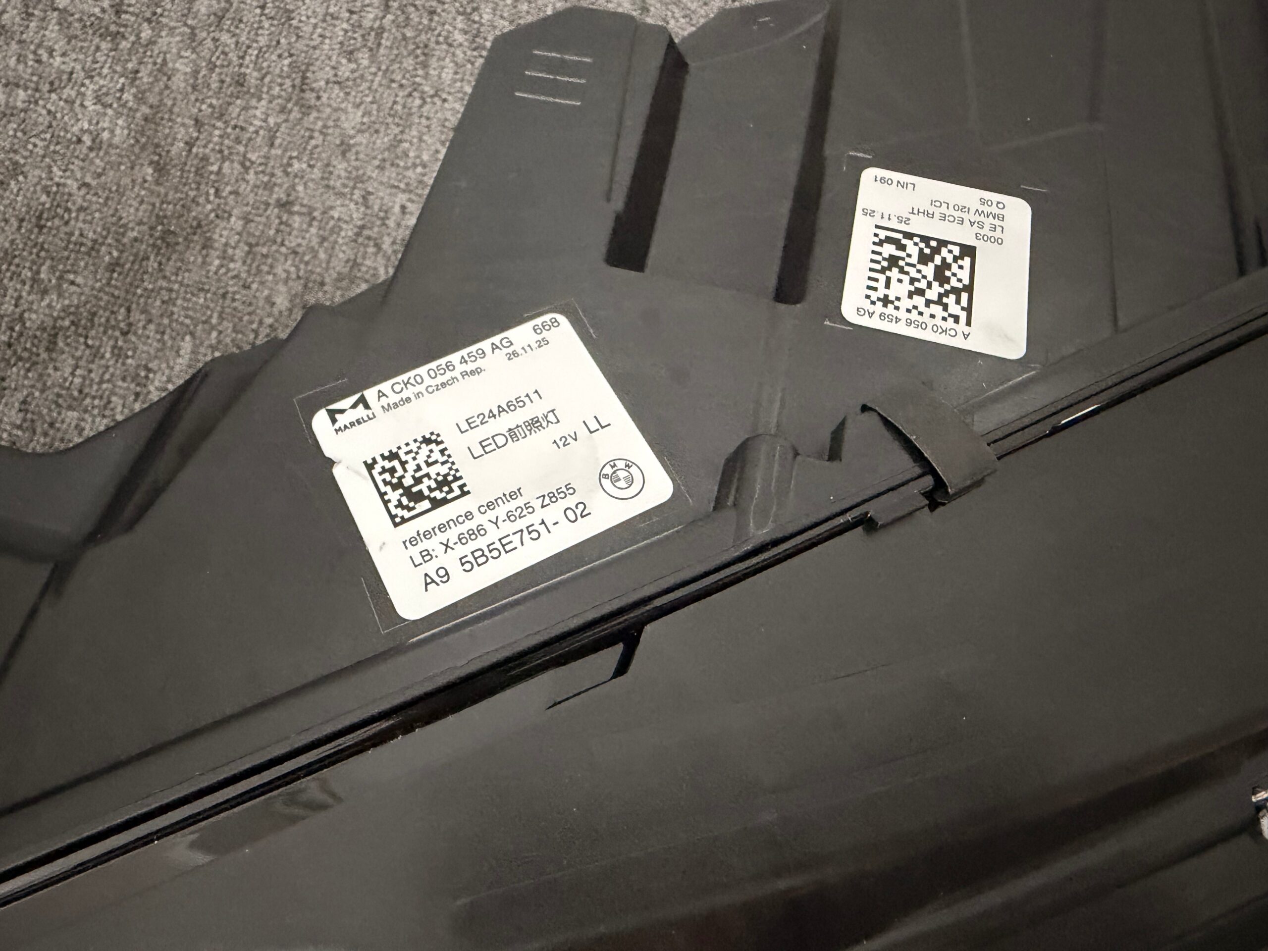 BMW iX I20 LCI left headlight housing label (Magneti Marelli, Made in Czech Republic) showing OE A9 5B5E751-02, ECE RHT