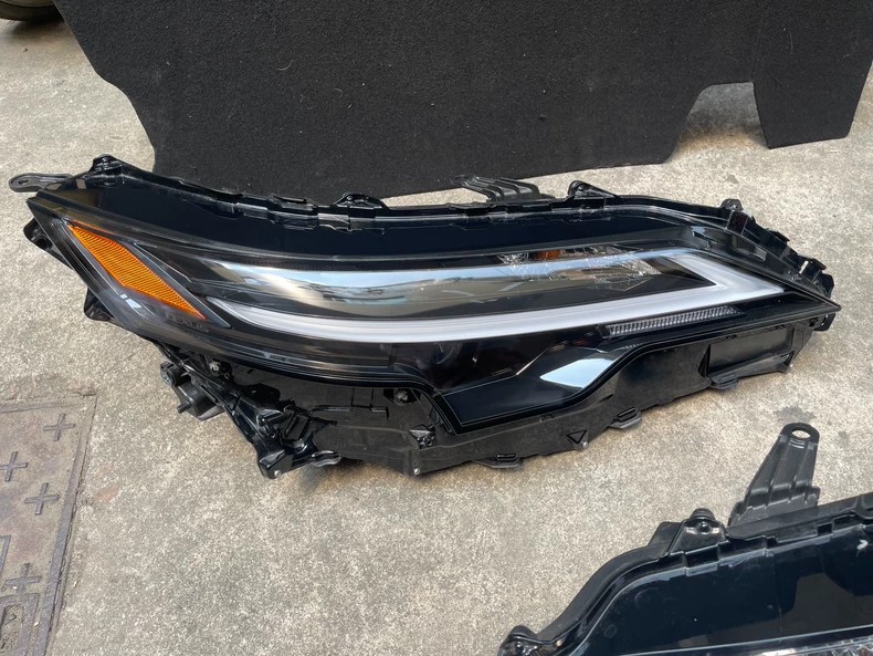 2025 Lexus RX450H used OEM LED headlight left side unit front three-quarter view with LED daytime running light strip